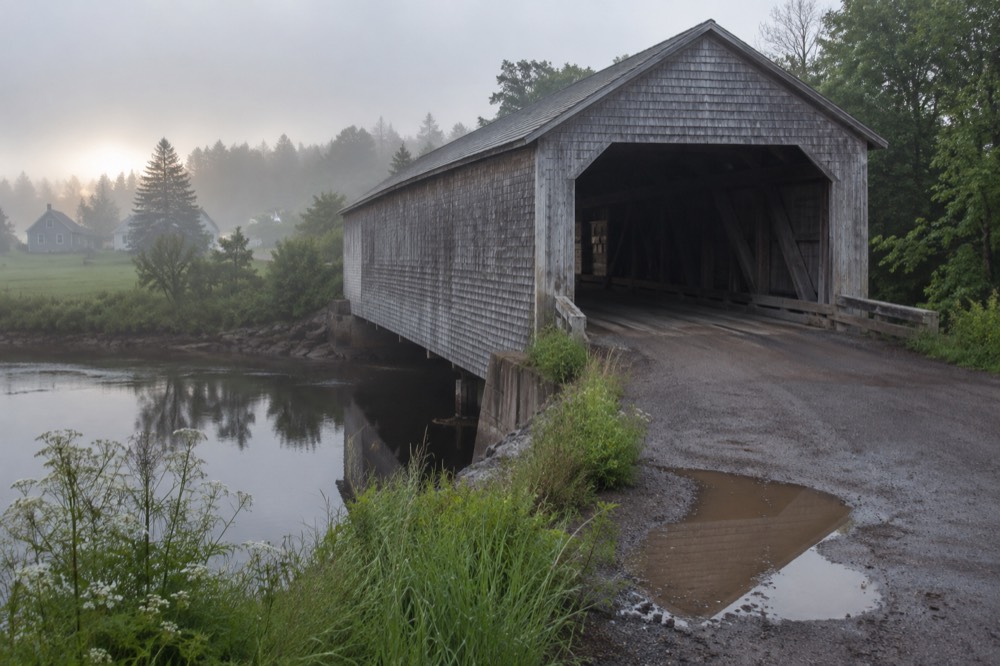 A covered bridge over a quiet stream in rural Prince Edward Island