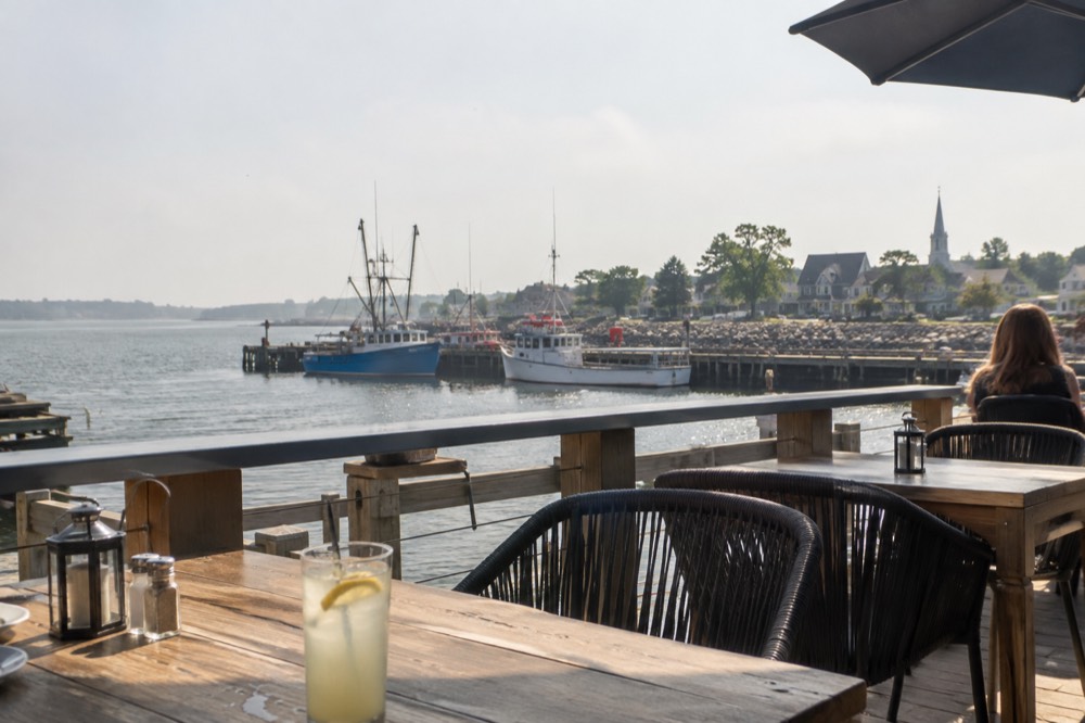 Waterfront restaurant patio with harbour water beyond the railing