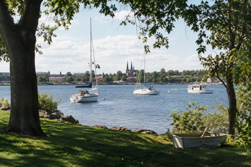 Sailboats and tour boats moored in Charlottetown harbour under an afternoon sky