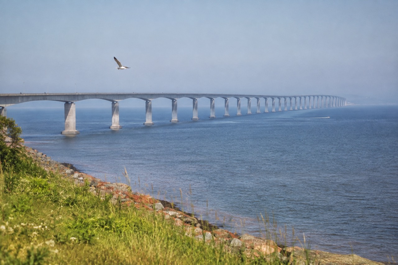 The long Confederation Bridge curving across blue water toward Prince Edward Island