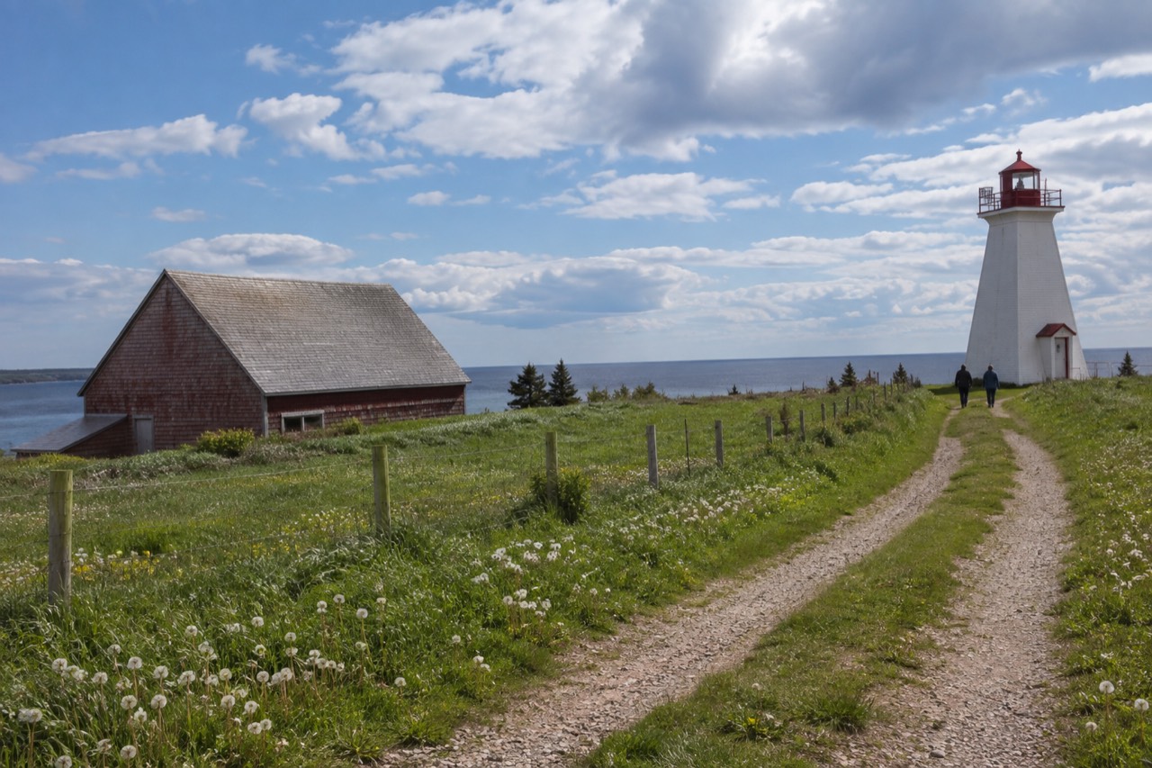 A stone dust trail cutting through green Prince Edward Island farmland under a wide sky