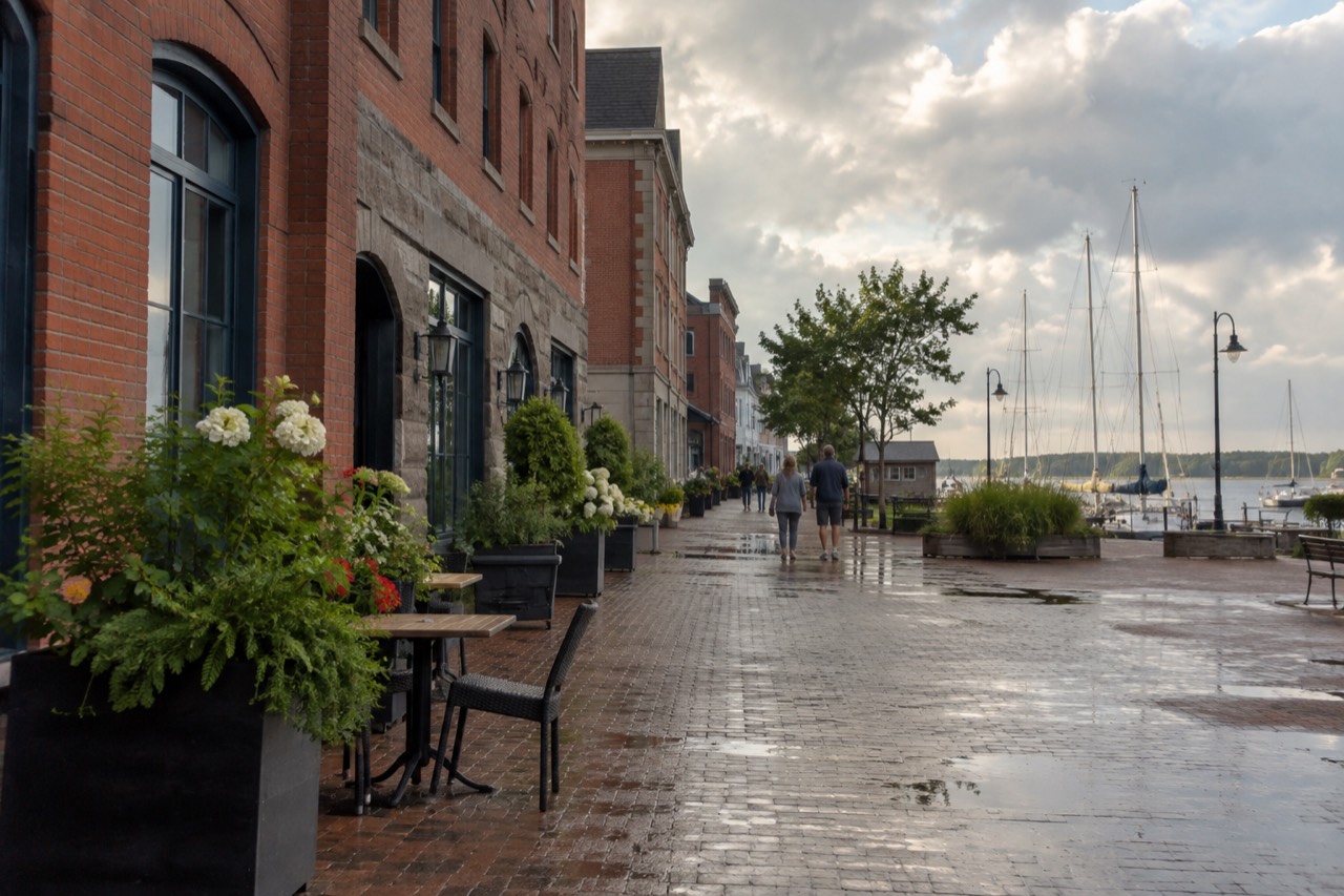 Historic brick and stone buildings along a Charlottetown waterfront street under a summer sky