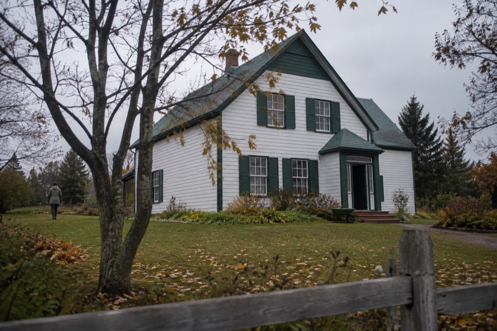 White farmhouse with green gables surrounded by trees in Cavendish