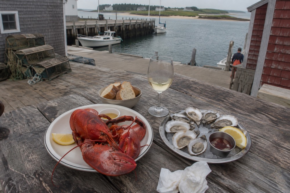 Fresh lobster and oysters on a wooden dockside table