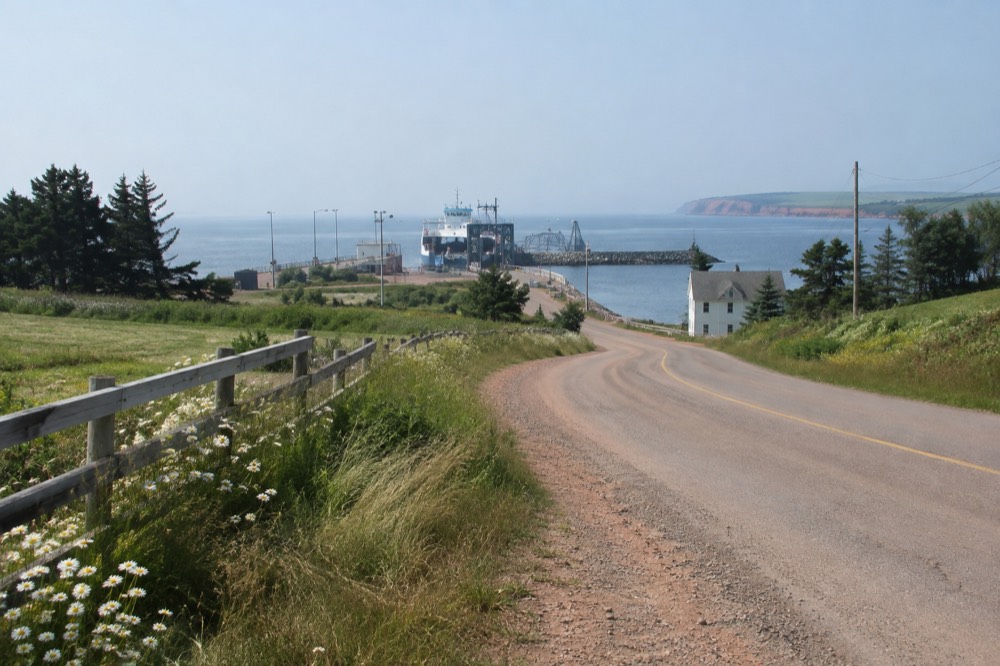 A quiet country road curving through rolling green farmland