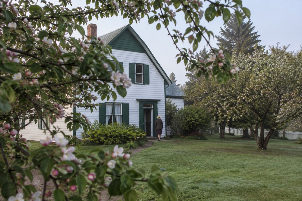 White farmhouse with green gables surrounded by orchard trees in Cavendish