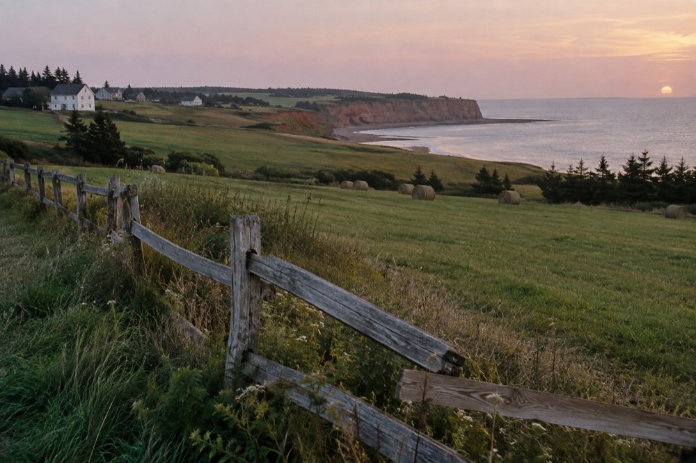 Wooden fence and farm fields rolling toward the sea near Cavendish