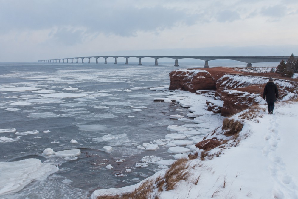 Snow-covered red sandstone cliffs along an empty winter coastline