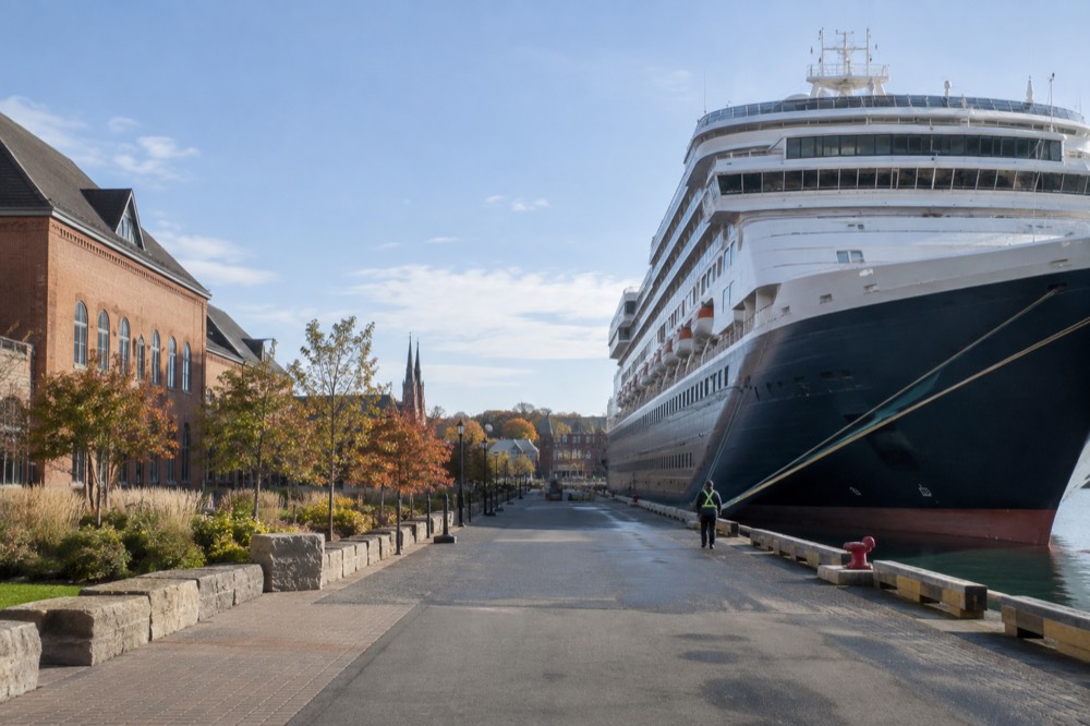 A cruise ship at berth beside a small city waterfront with historic buildings