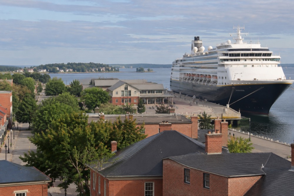 Cruise ship moored at the Charlottetown waterfront with historic brick buildings behind it