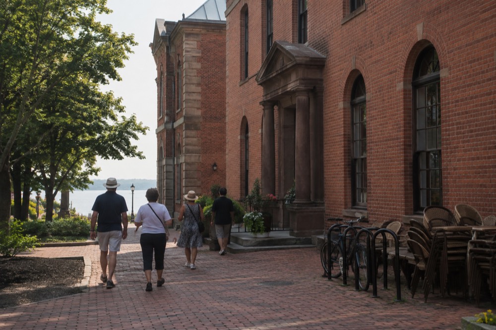 Tour group walking past red brick heritage buildings on a Charlottetown side street