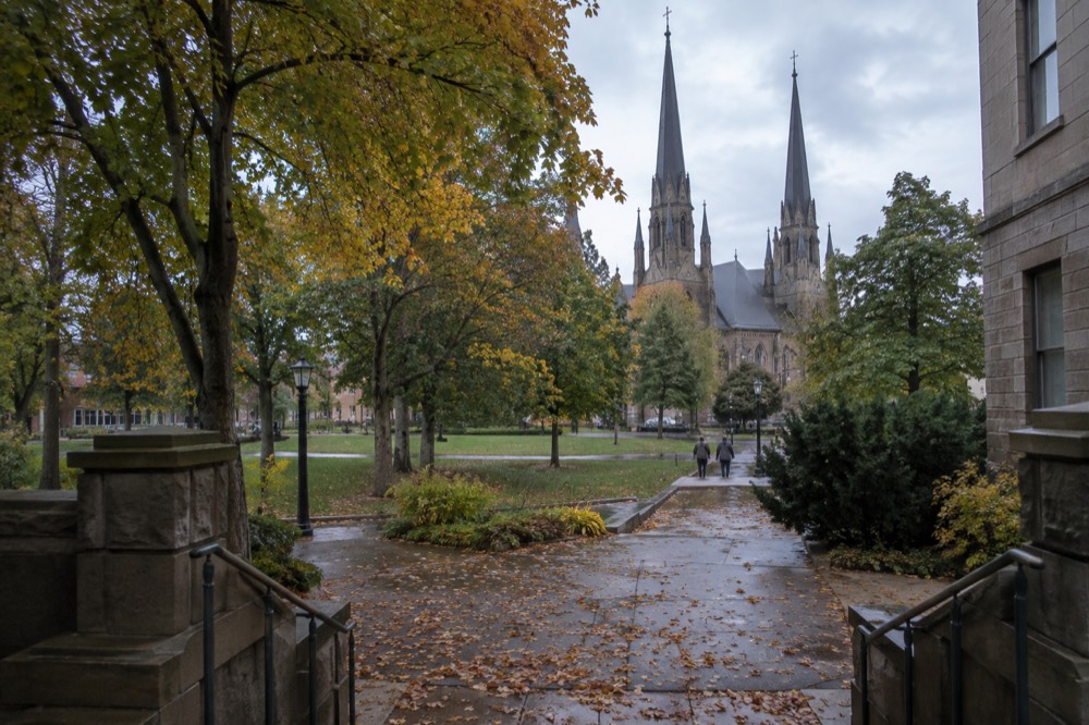 Stone church spire rising above tree-lined street in historic Charlottetown