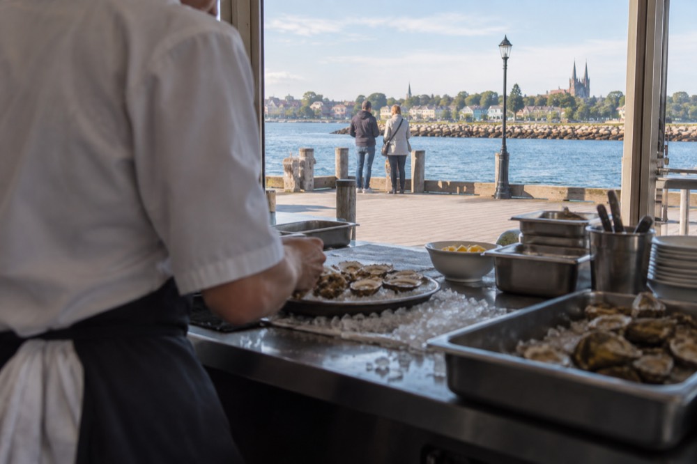 Chef plating fresh Island seafood at an open kitchen counter