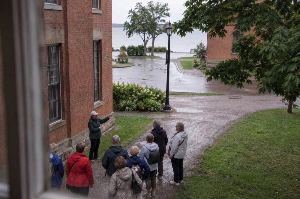 Tour guide speaking to a small group gathered on a historic Charlottetown street corner