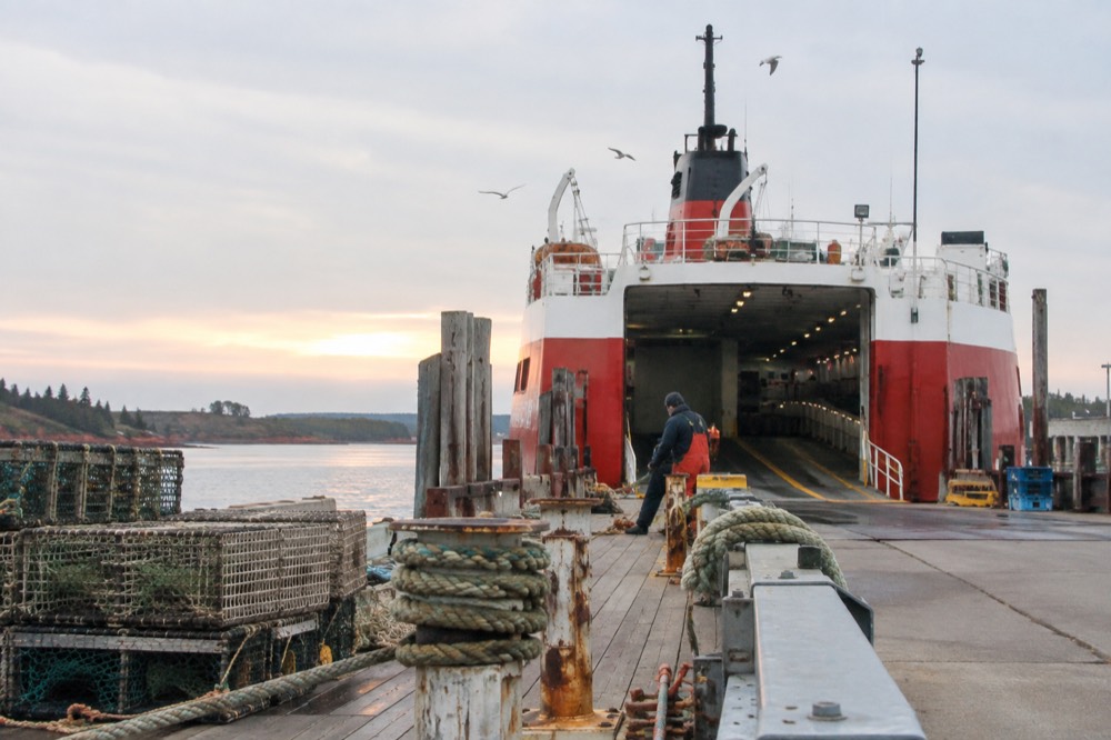 A ferry vessel loading cars at a small island wharf on a calm morning