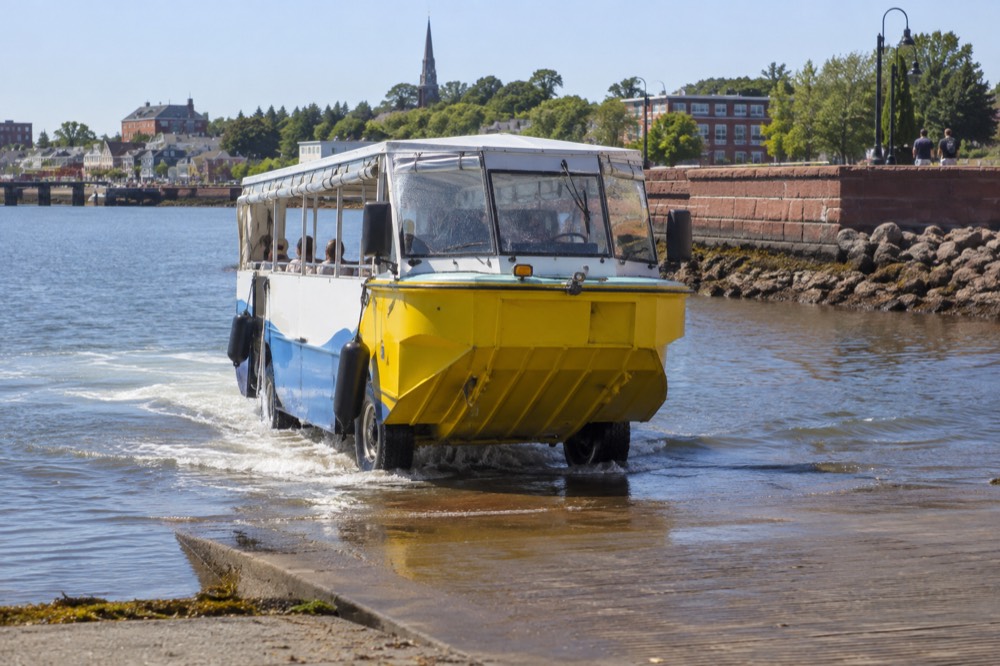 An amphibious tour vehicle driving down a launch ramp into Charlottetown harbour