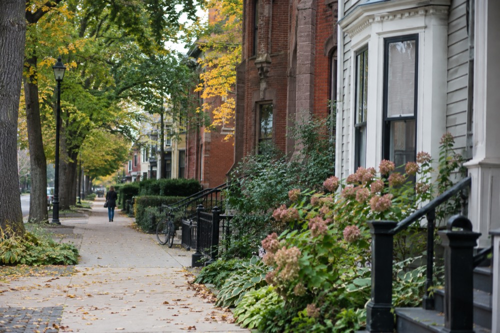 Historic brick and clapboard buildings along a tree-lined Charlottetown street