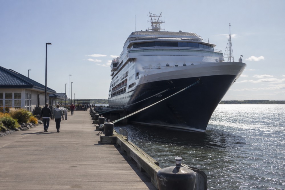A cruise ship at berth beside a waterfront boardwalk in Charlottetown harbour