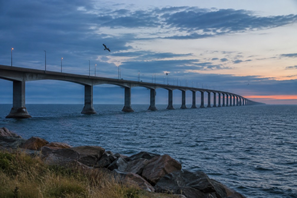 A long bridge curving over open water toward land